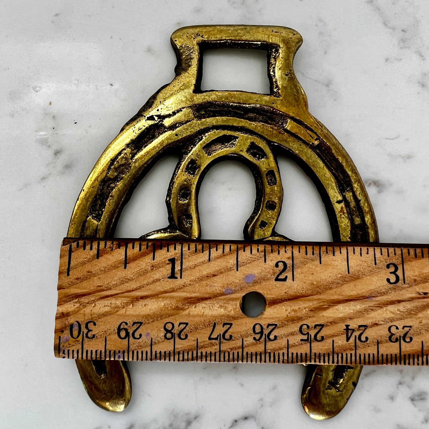 Vintage double horseshoe brass medallion necklace with dark multi-strand beads and leather connector.