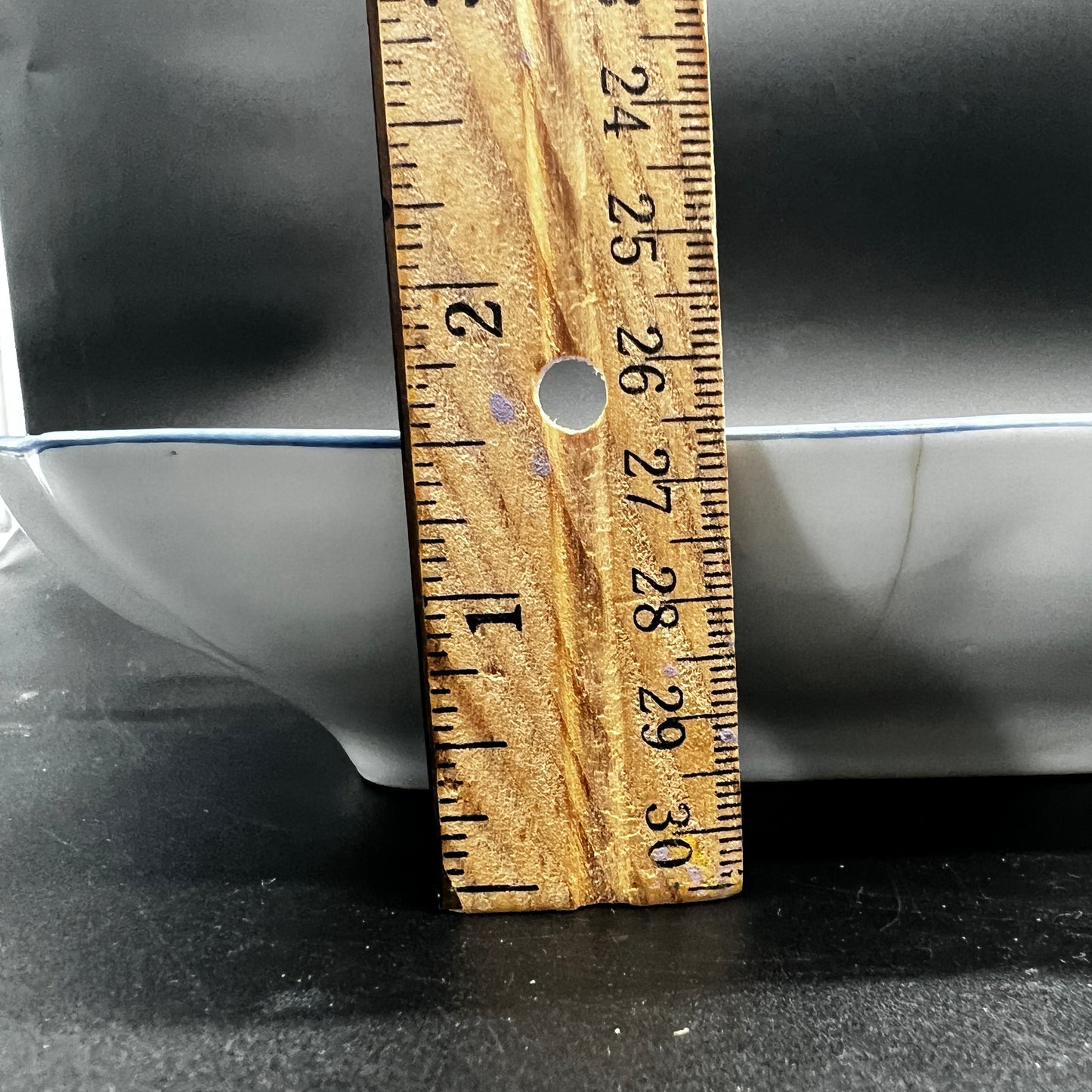 Wooden ruler with measurements on a black surface

