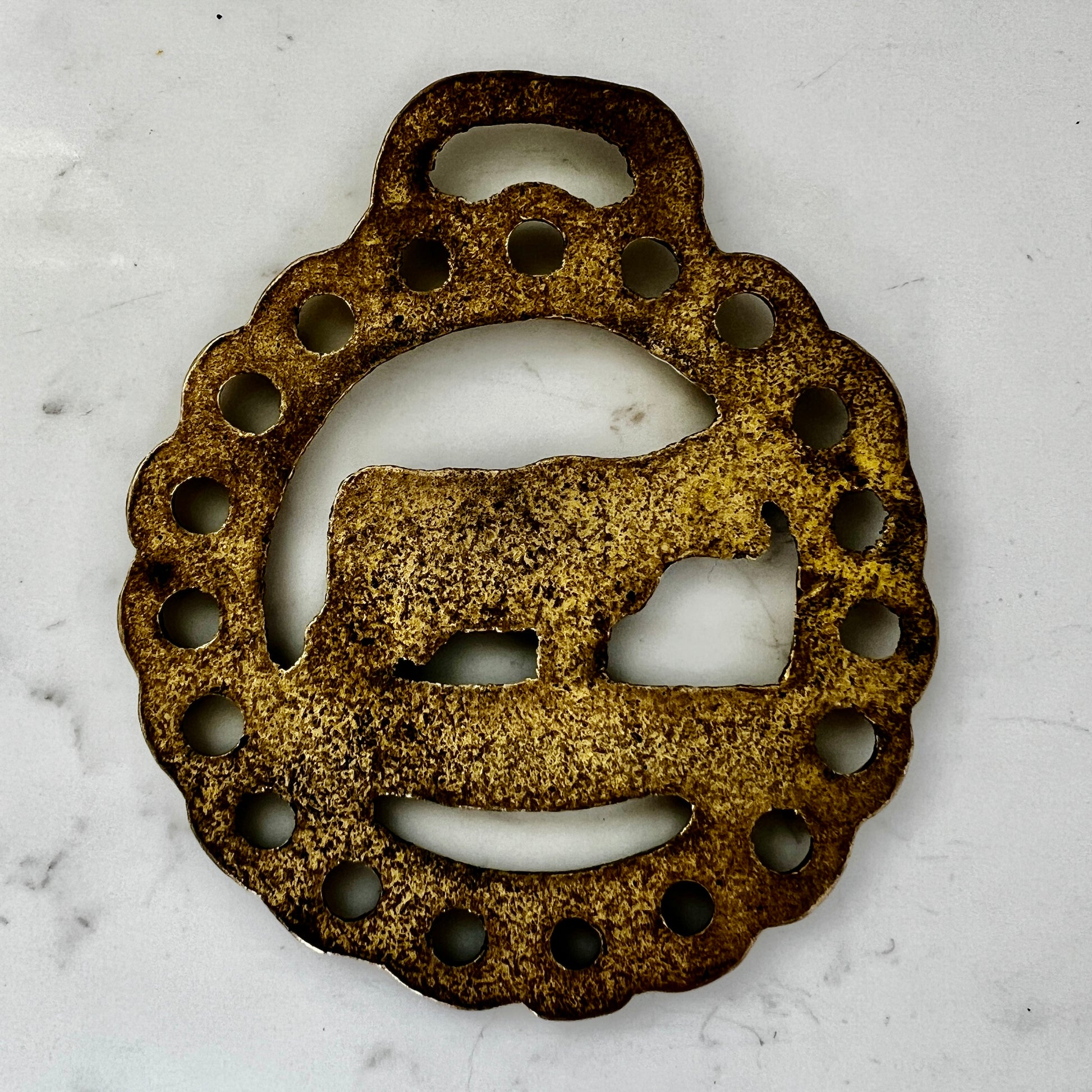 Vintage cow horse brass medallion attached to brown leather keychain with brass hardware.