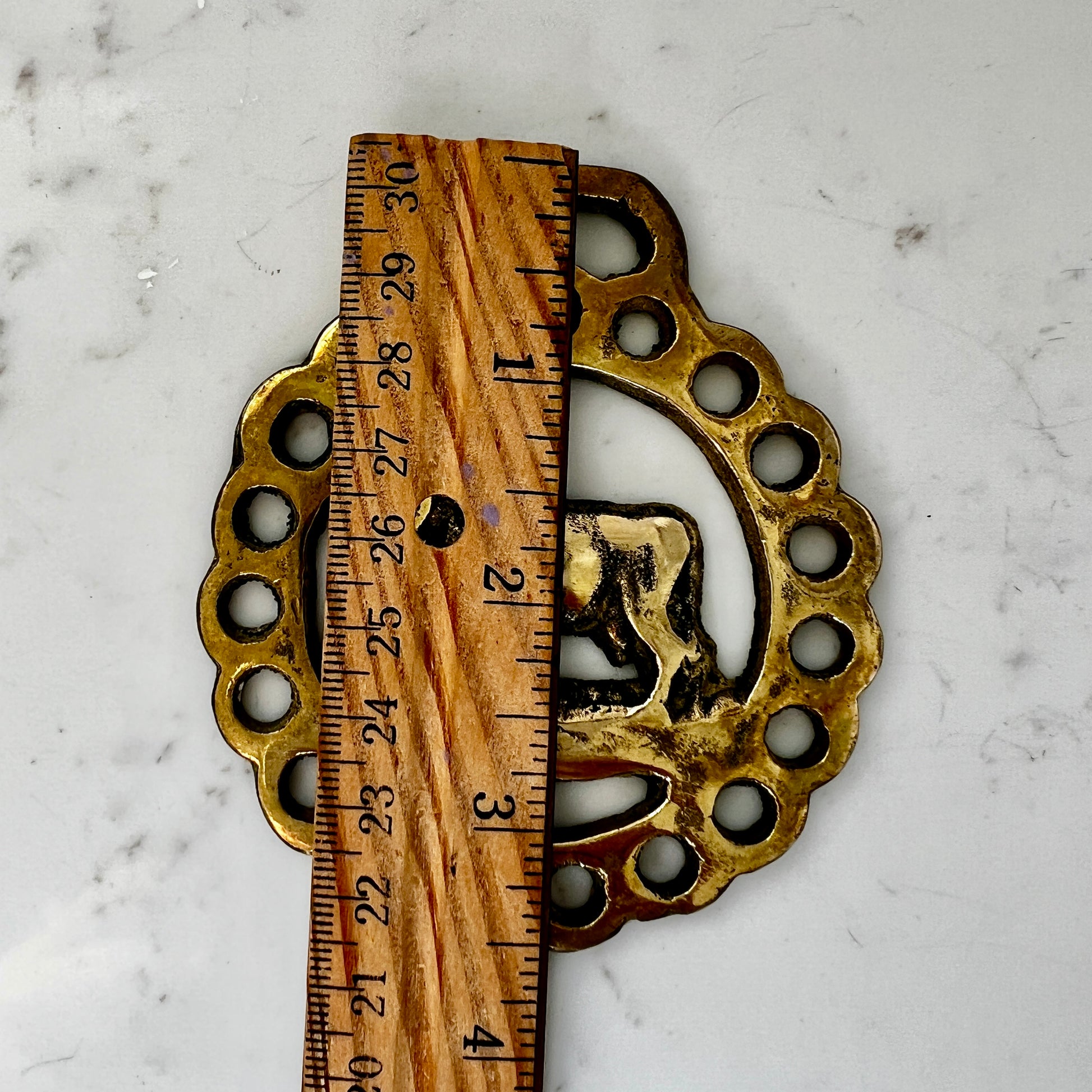 Vintage cow horse brass medallion attached to brown leather keychain with brass hardware.