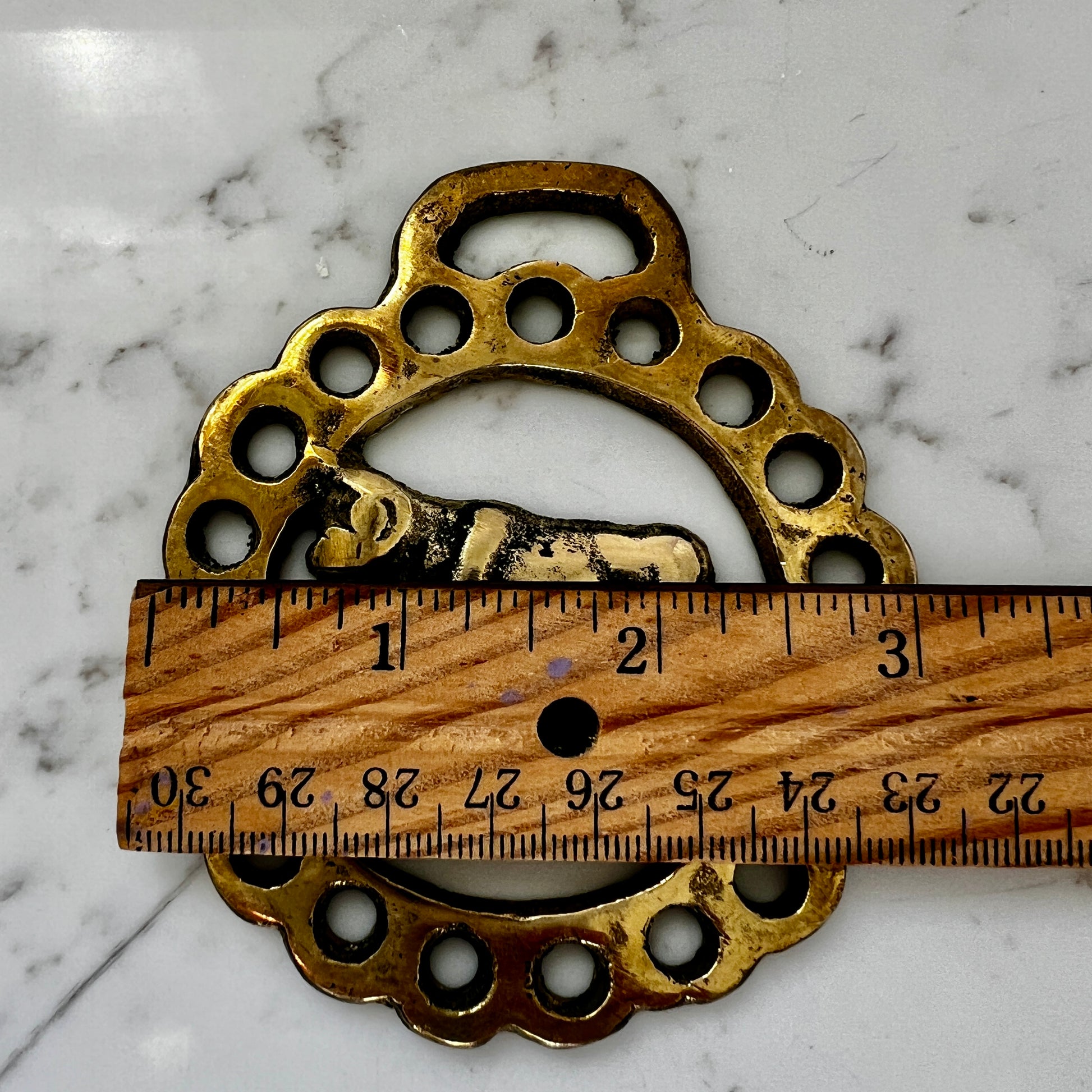 Vintage cow horse brass medallion attached to brown leather keychain with brass hardware.