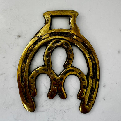 Vintage double horseshoe brass medallion necklace with dark multi-strand beads and leather connector.