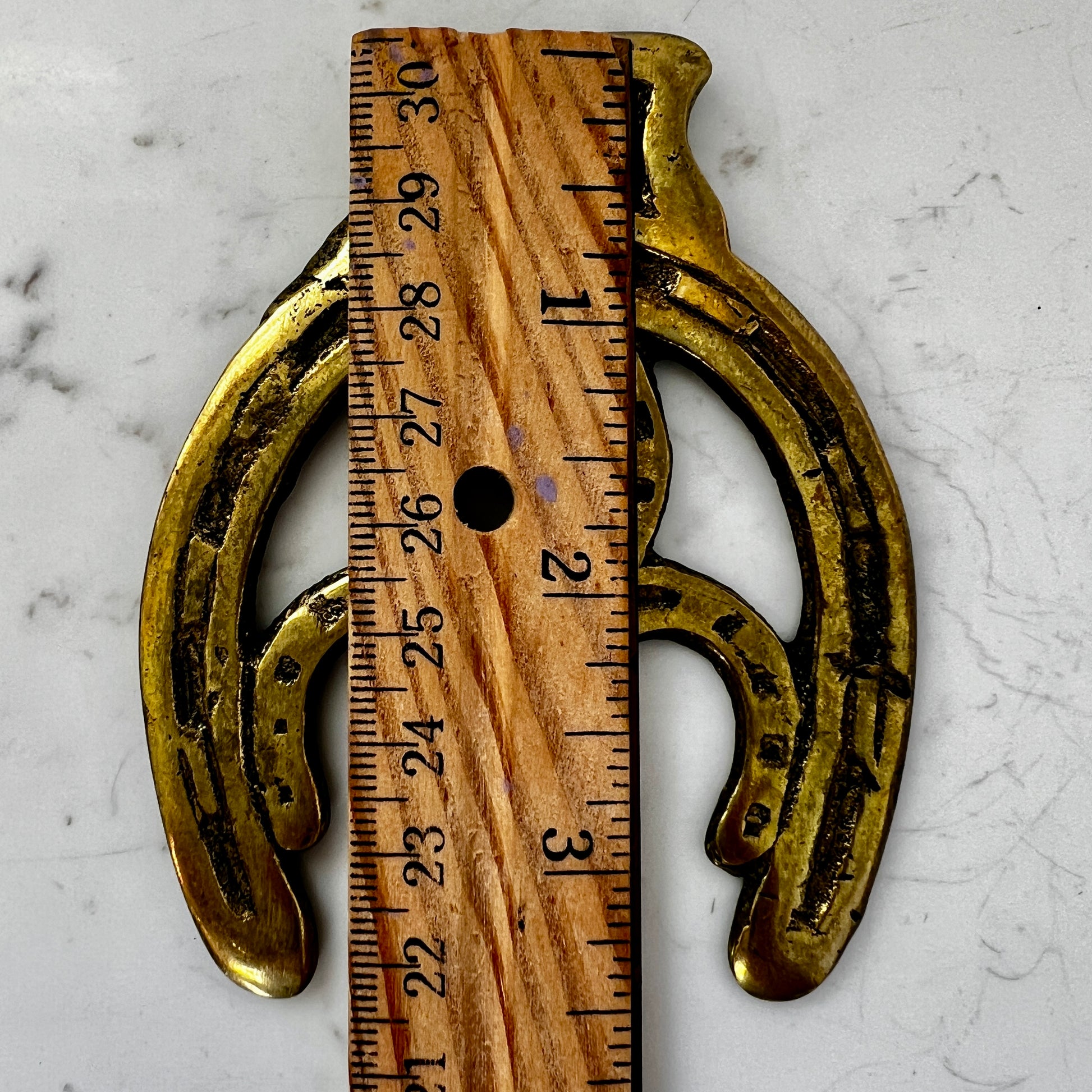 Vintage double horseshoe brass medallion necklace with dark multi-strand beads and leather connector.