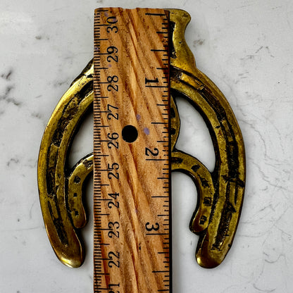 Vintage double horseshoe brass medallion necklace with dark multi-strand beads and leather connector.