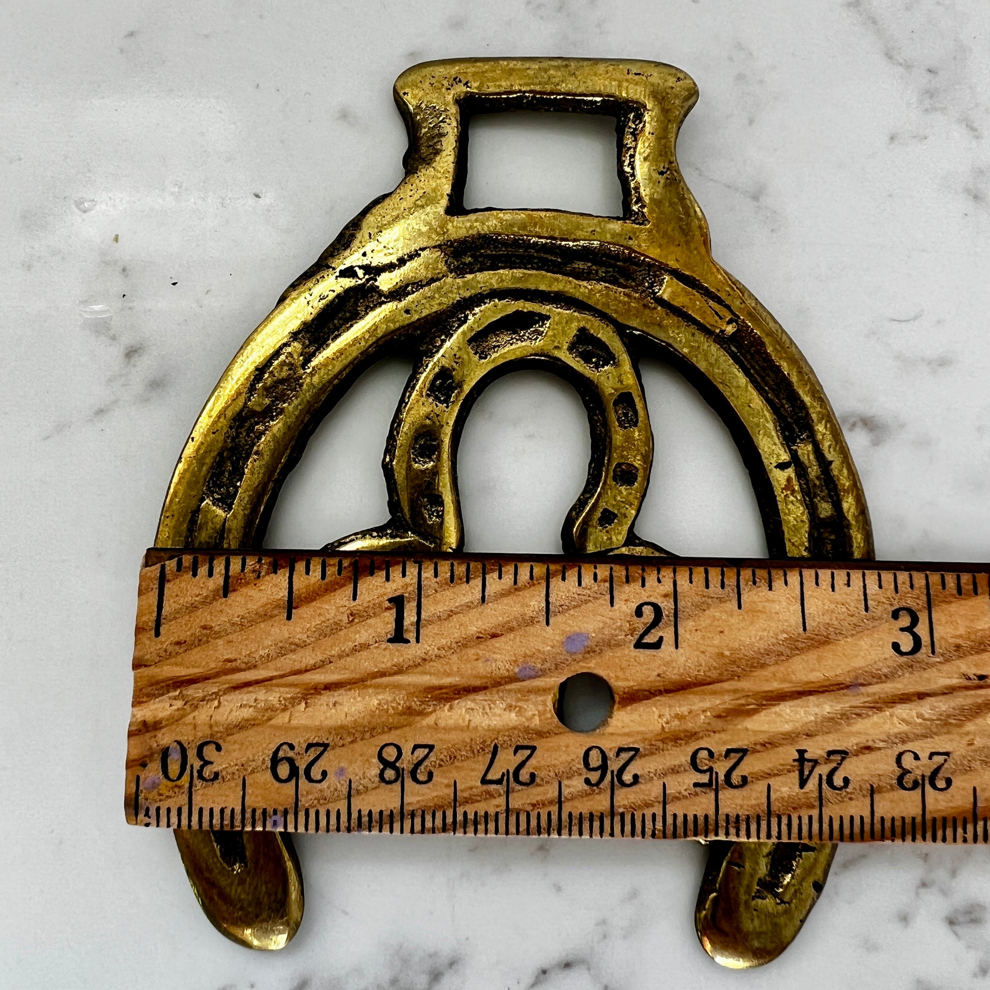 Vintage double horseshoe brass medallion necklace with dark multi-strand beads and leather connector.