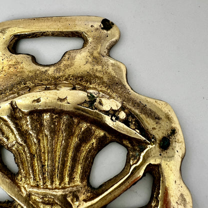 Vintage scythe and wheat horse brass medallion attached to triple-strand black and cream beaded necklace with leather connector.