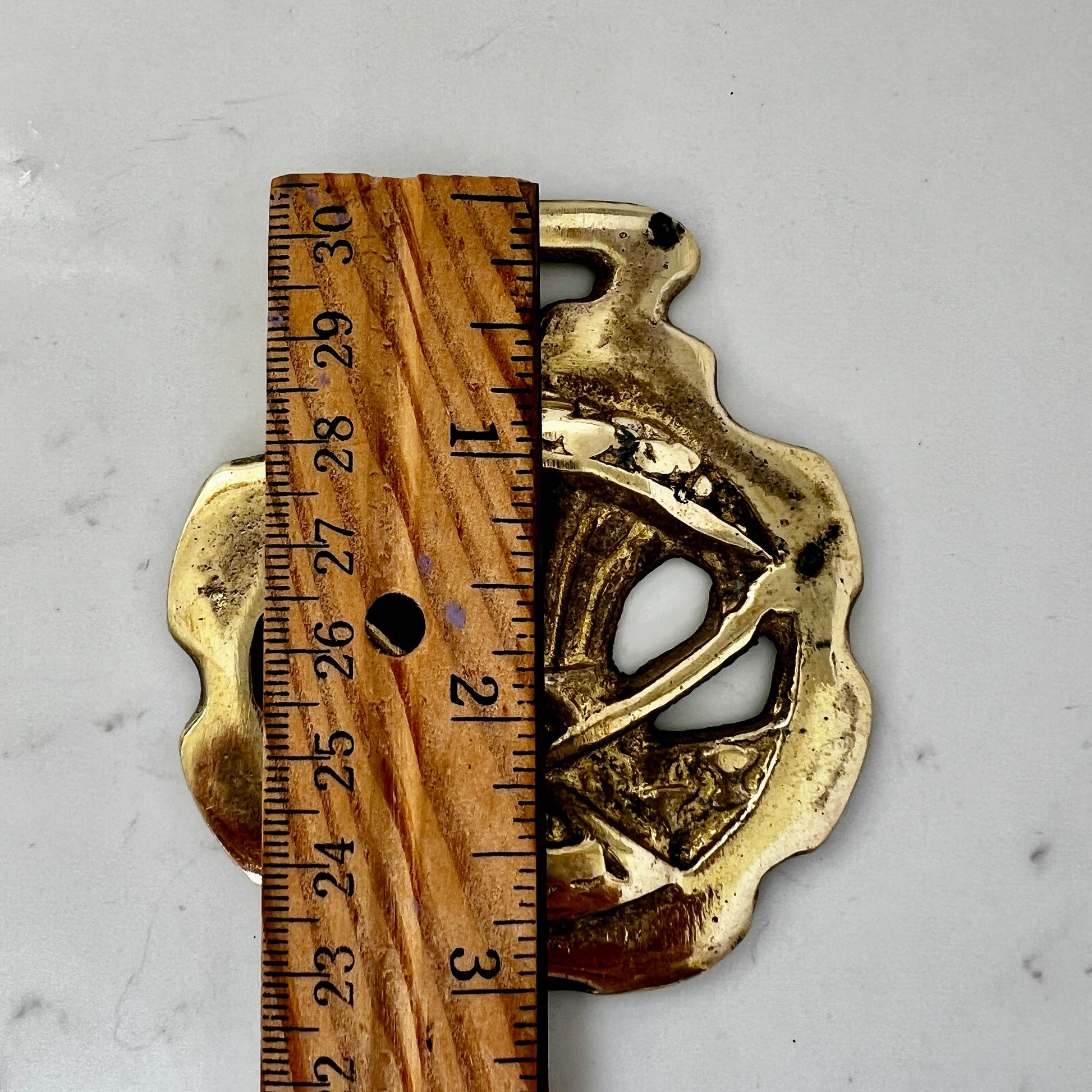 Vintage scythe and wheat horse brass medallion attached to triple-strand black and cream beaded necklace with leather connector.