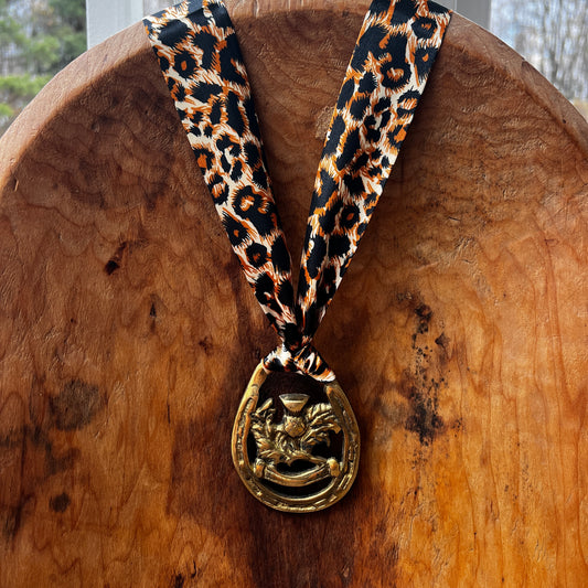 Vintage brass Scottish thistle medallion necklace with leopard-print scarf, rustic boho jewelry.