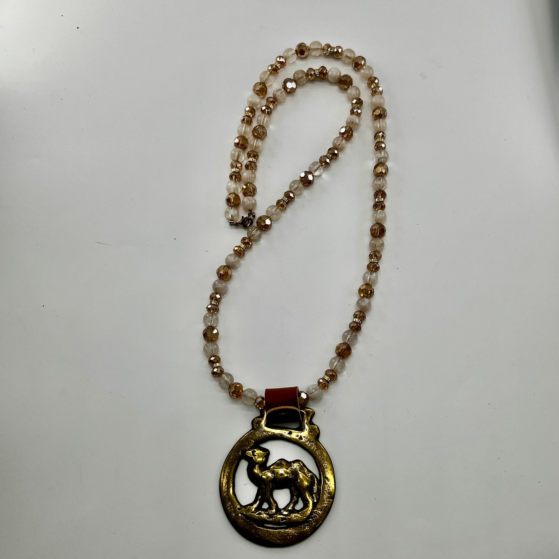 Vintage camel horse brass medallion on double-strand neutral beaded necklace with caramel leather connector.