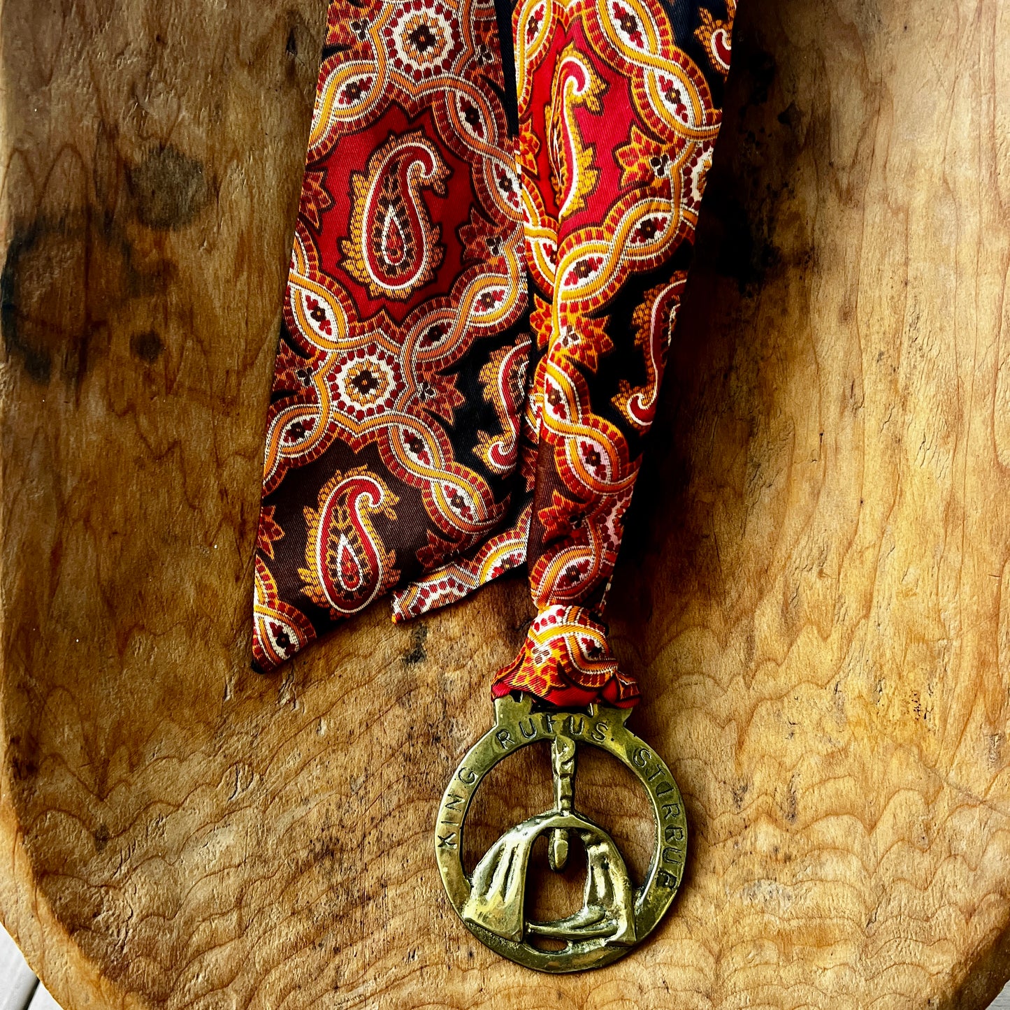 Vintage King Rufus Stirrup brass medallion necklace with red paisley scarf, equestrian jewelry.