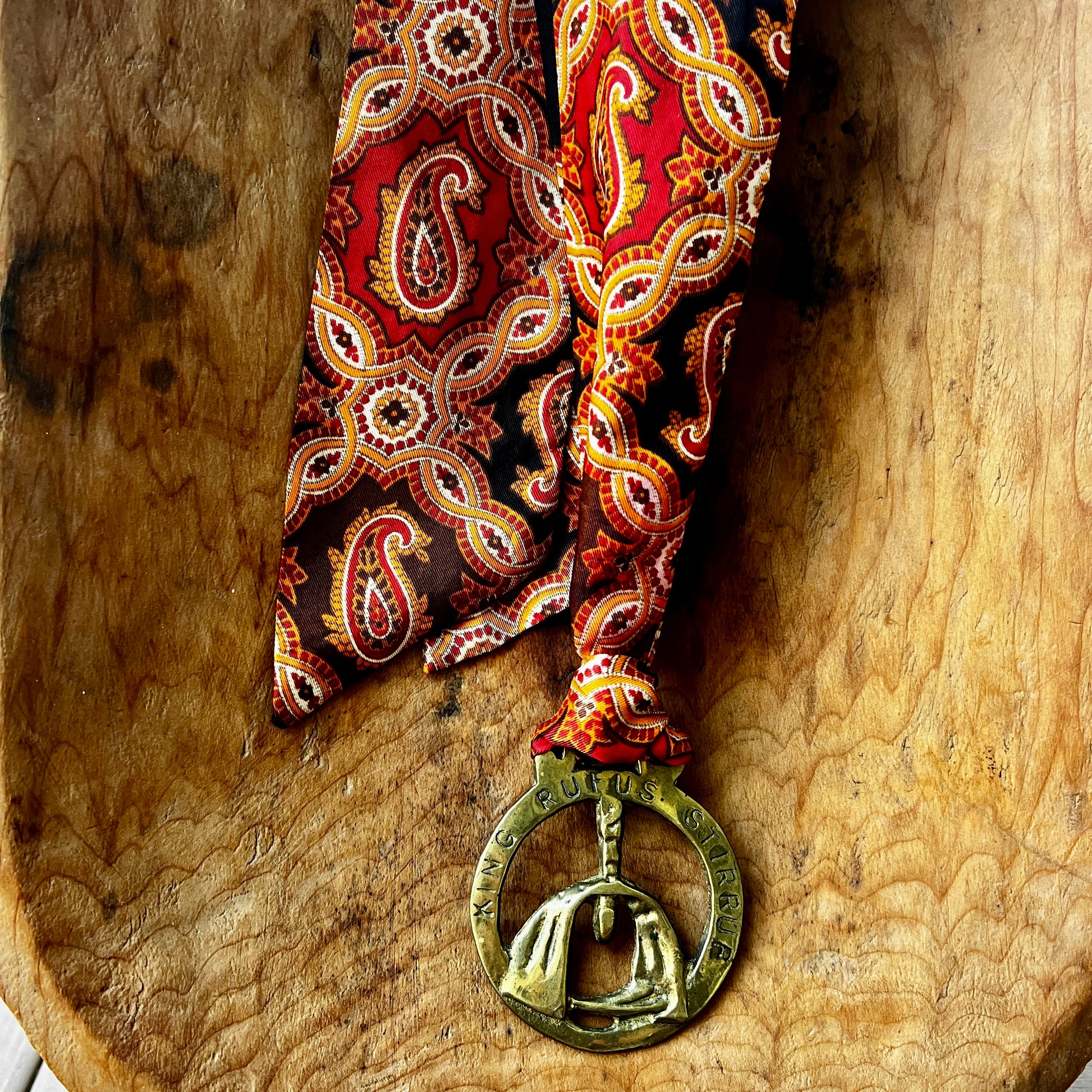 Vintage King Rufus Stirrup brass medallion necklace with red paisley scarf, equestrian jewelry.