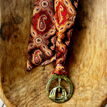 Vintage King Rufus Stirrup brass medallion necklace with red paisley scarf, equestrian jewelry.