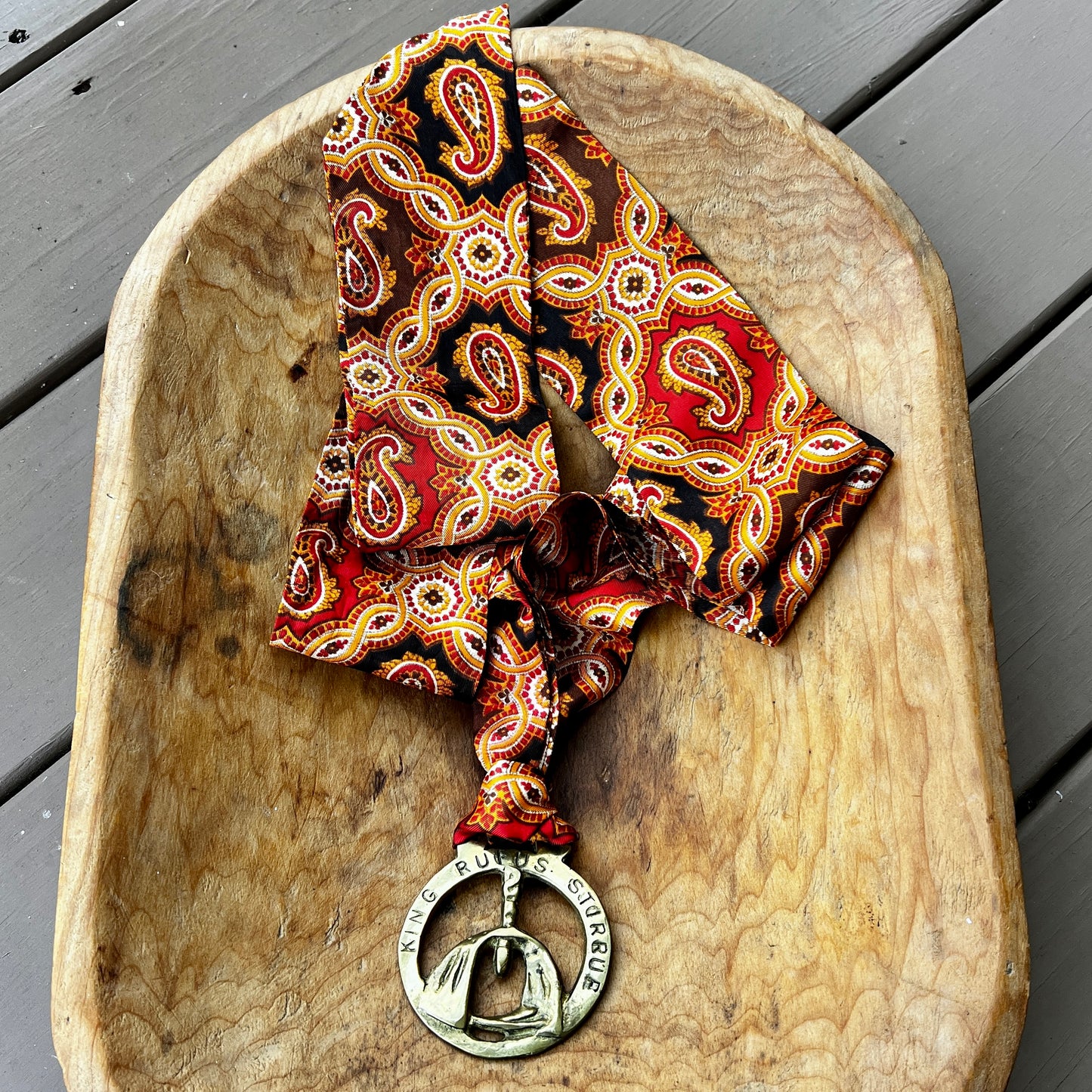 Vintage King Rufus Stirrup brass medallion necklace with red paisley scarf, equestrian jewelry.