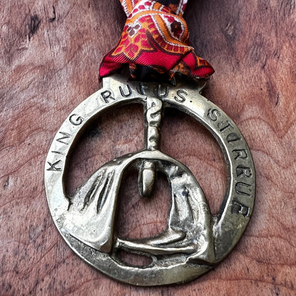 Vintage King Rufus Stirrup brass medallion necklace with red paisley scarf, equestrian jewelry.