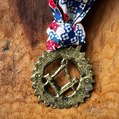 Back of Vintage Masonic square and compass brass medallion necklace with red white blue scarf.