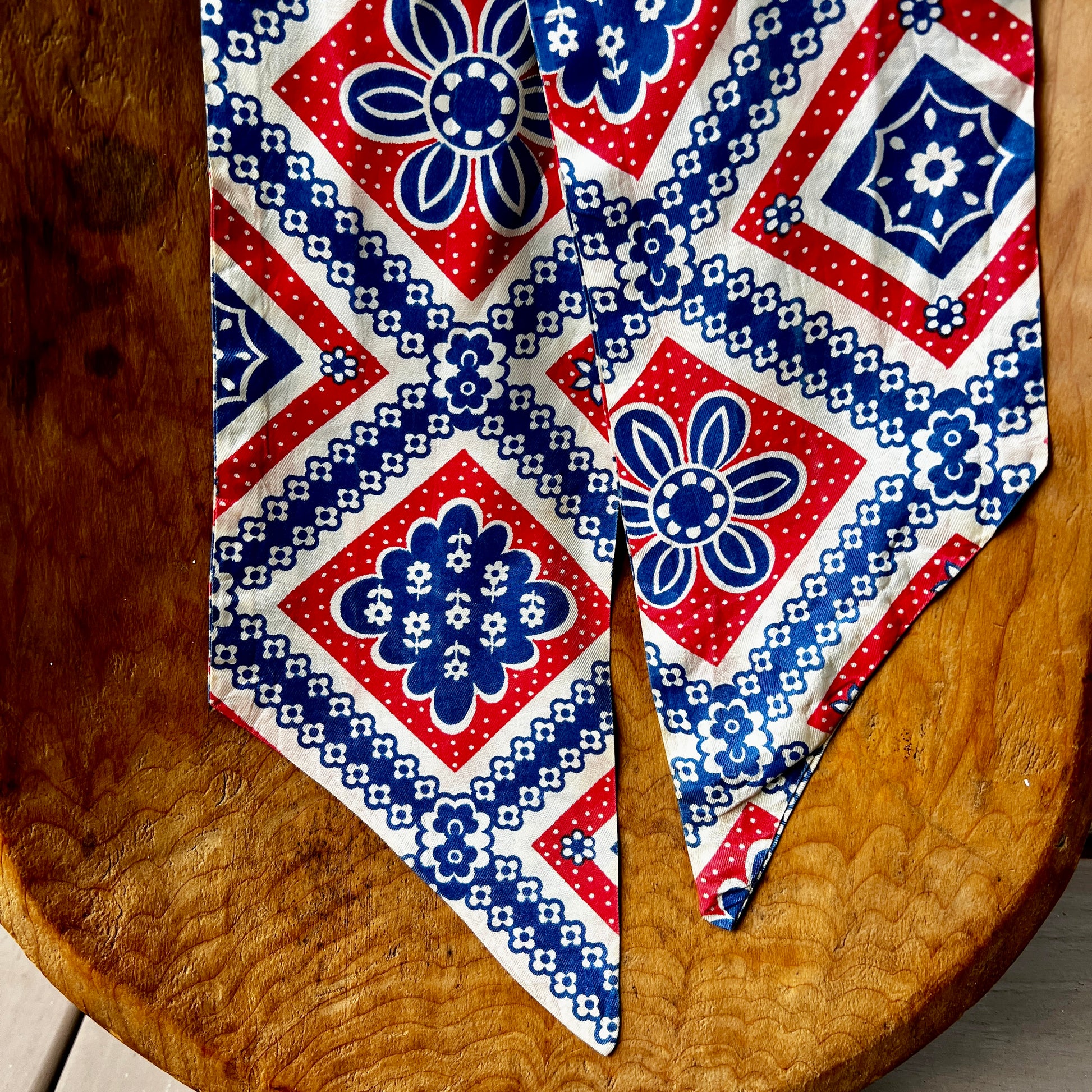Red, white, and blue patterned tie on a wooden surface