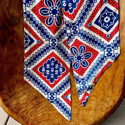 Red, white, and blue patterned tie on a wooden surface