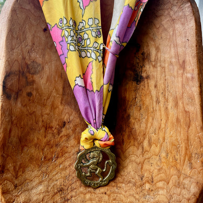 Vintage Red Lion London brass medallion necklace with bright retro floral scarf.