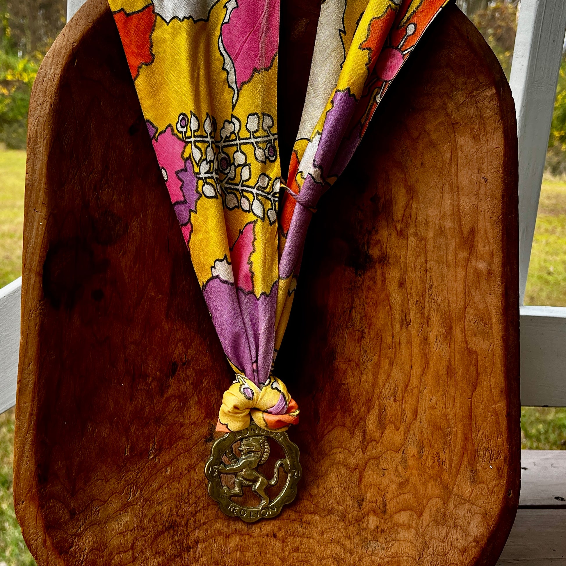 Vintage Red Lion London brass medallion necklace with bright retro floral scarf.