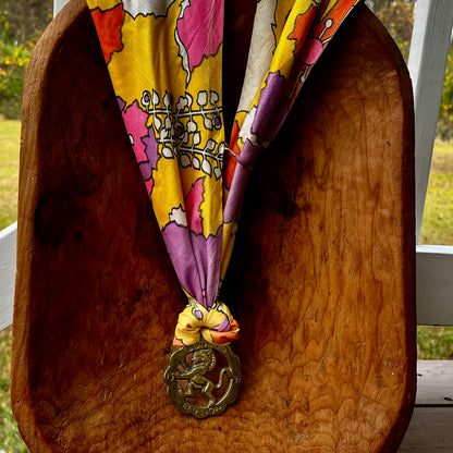 Vintage Red Lion London brass medallion necklace with bright retro floral scarf.