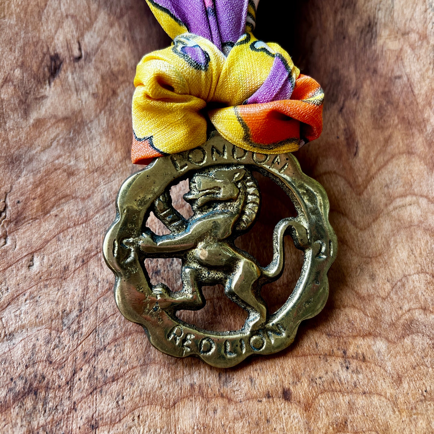 Vintage Red Lion London brass medallion necklace with bright retro floral scarf.
