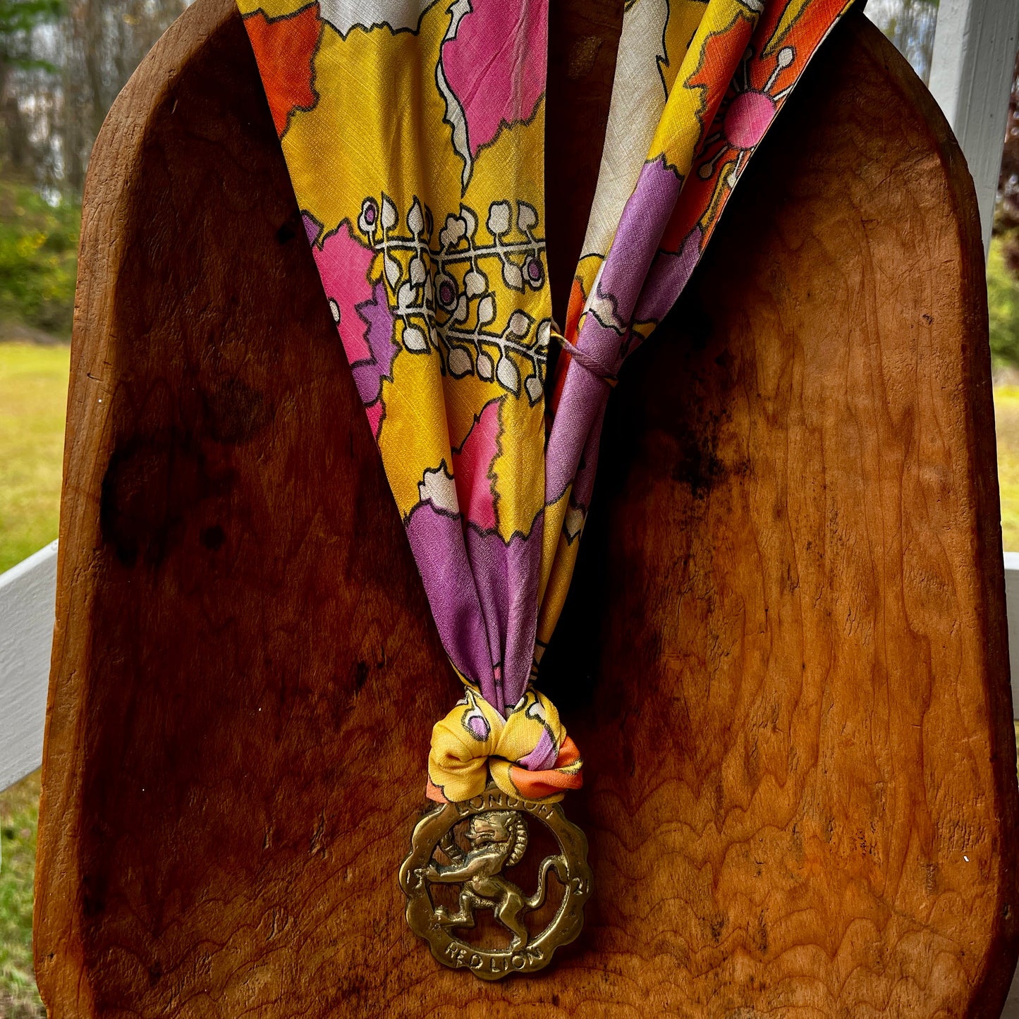Vintage Red Lion London brass medallion necklace with bright retro floral scarf.