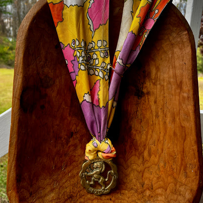 Vintage Red Lion London brass medallion necklace with bright retro floral scarf.