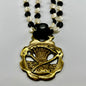 Vintage scythe and wheat horse brass medallion attached to triple-strand black and cream beaded necklace with leather connector.