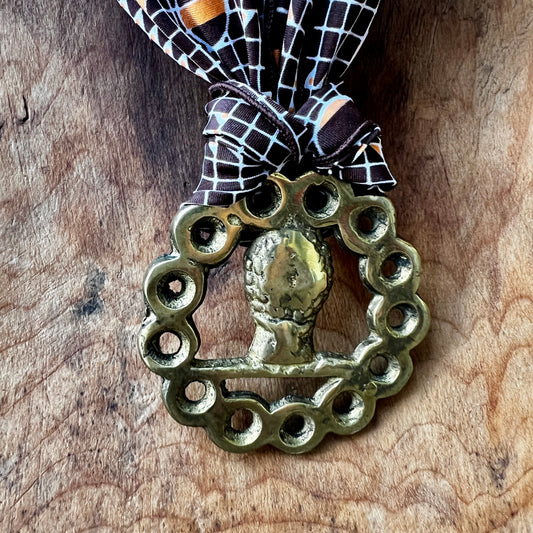 Vintage horse brass medallion necklace with geometric scarf, rustic equestrian jewelry.