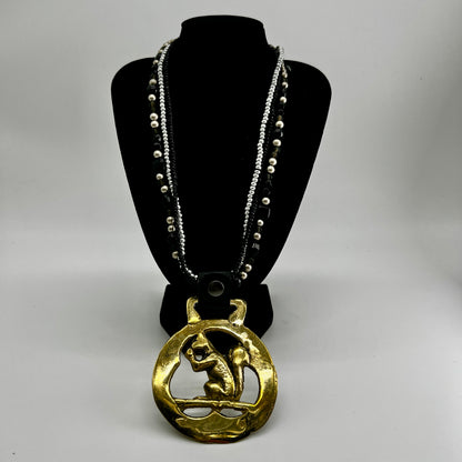 Vintage squirrel brass horse medallion on multi-strand black and silver beaded necklace with leather connector.