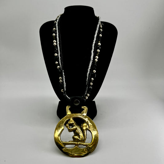 Vintage squirrel brass horse medallion on multi-strand black and silver beaded necklace with leather connector.