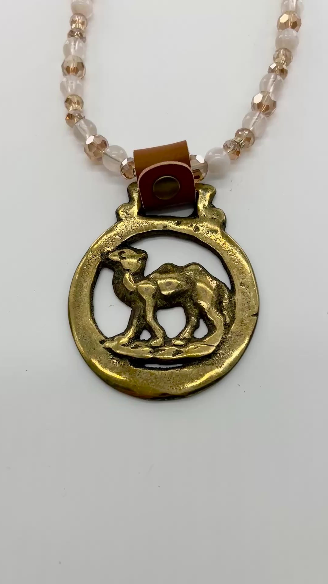Vintage camel horse brass medallion on double-strand neutral beaded necklace with caramel leather connector.