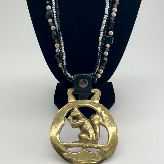 Vintage squirrel brass horse medallion on multi-strand black and silver beaded necklace with leather connector.VIDEO