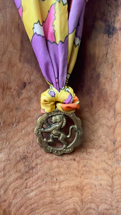 Video of Vintage Red Lion London brass medallion necklace with bright retro floral scarf.